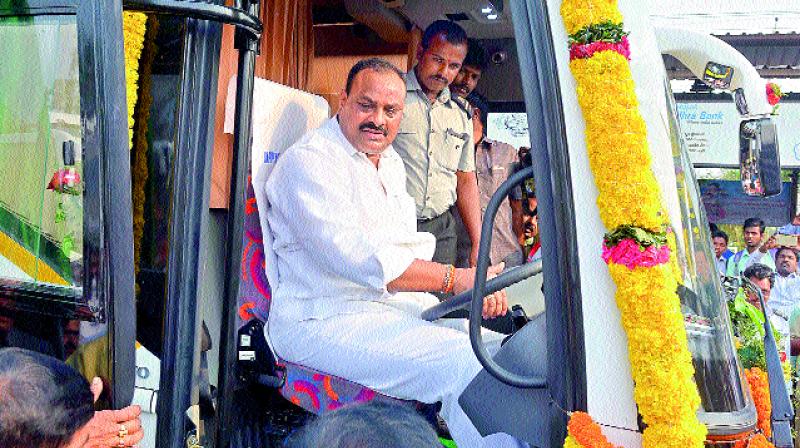 Minister K. Atchennaidu drives a Volvo bus after inaugurating one at the city terminal in Vijayawada on Monday. (Photo: DC)