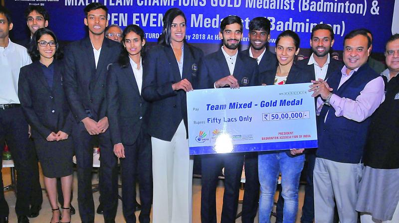 Members of the Indian badminton contingent at the Commonwealth Games in Gold Coast are all smiles while being presented a cheque for 50 lakhs by Badminton Association of India president Himanta Biswa Sarma in New Delhi on Saturday night.