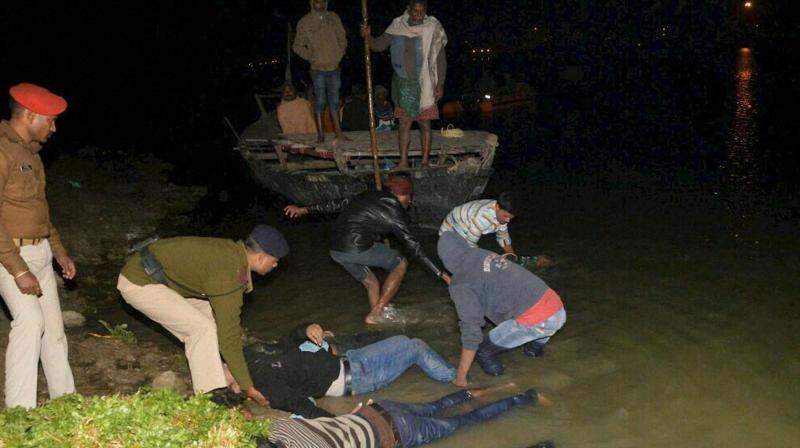 SDRF team rescue dead bodies of passengers of a boat which capsized in Ganga river in Patna on Saturday. (Photo: PTI)