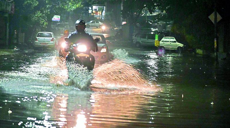 A motorist rides through a flooded road at Padmaraonagar in Secunderabad following the heavy downpour on Saturday night. 	 Style photo service