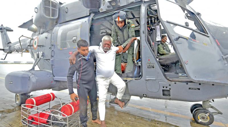 An Indian fisherman who was stranded in the Arabian Sea is escorted down from an Indian Navy helicopter after being rescued in Thiruvananthapuram, Kerala (Photo: AP)