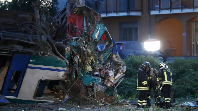 Firemen work next to the twisted wreckage of a train that plowed into a big-rig truck in Caluso, outside Turin, Italy, early Thursday. (Photo: AP)