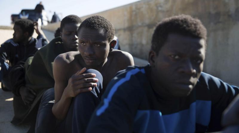 Migrants rest on the sidewalk port of Tripoli they were rescued by the Coast Guard off the coast of Tripoli, Libya. (Photo: AP)