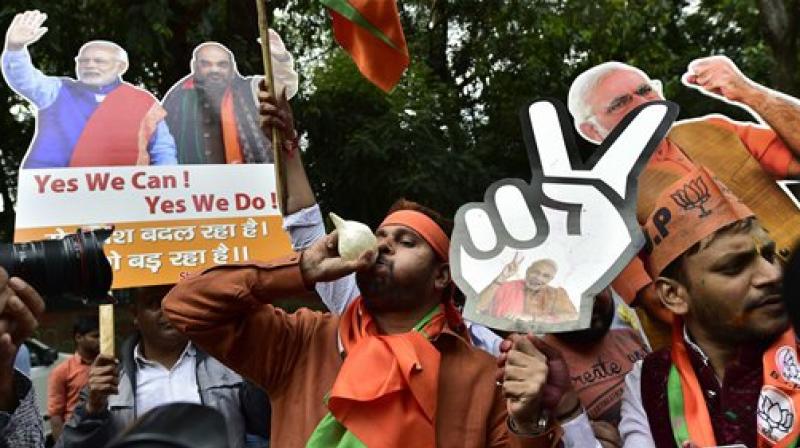 BJP supporters and workers celebrate partys victory in the assembly elections, at the party head quarters in New Delhi on Saturday. (Photo: PTI)