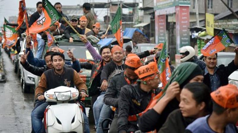 Supporters of BJP celebrate their candidates win in the Assembly elections in Imphal on Saturday. (Photo: PTI)