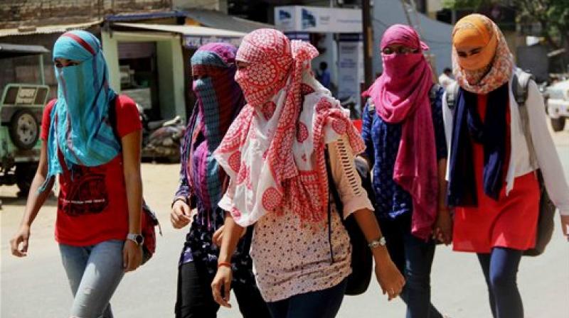 Girls cover their faces to protect themselves from scorching heat in Allahabad on Thursday. (Photo: PTI)