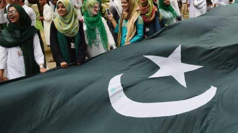 University of Karachi students celebrate with a large national flag ahead of the upcoming Independence Day in Karachi on August 13, 2018. (Photo: AFP)