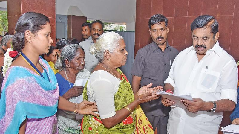 Chief Minister Edappadi K. Palanisami receives a petition from an elderly women at the Hasthampatti circuit house in Salem on Saturday.