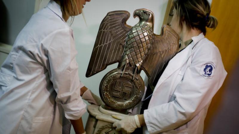 Members of the federal police carry a Nazi statue at the Interpol headquarters in Buenos Aires, Argentina, Friday, June 16, 2017. In a hidden room in a house near Argentinas capital, police discovered on June 8th the biggest collection of Nazi artifacts in the countrys history. Authorities say they suspect they are originals that belonged to high-ranking Nazis in Germany during World War II. (AP Photo/Natacha Pisarenko)