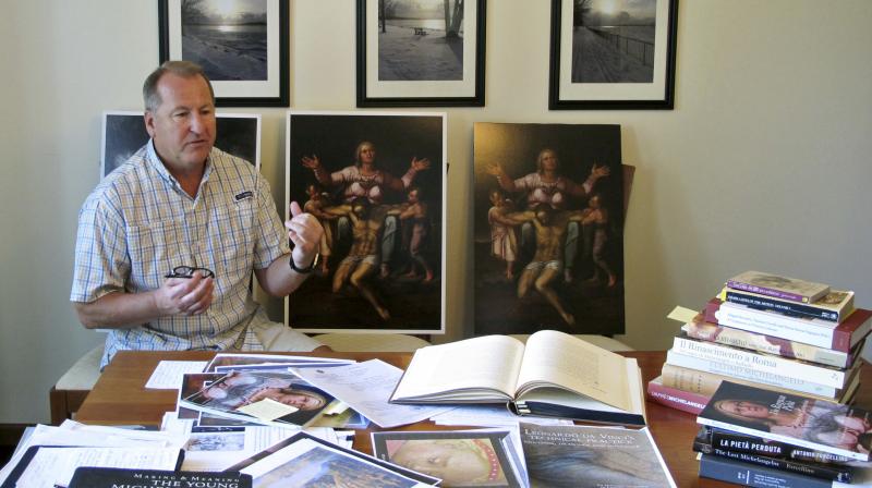 In this June 26, 2017 photo, Martin Kober displays literature and copies of a family heirloom that he believes was painted by Renaissance master Michelangelo, at his home in Tonawanda, N.Y. Kober is convinced the painting of a dying Jesus that hung above the mantel in his upstate New York childhood home is the work of Michelangelo. Getting experts to agree remains the $300 million hurdle. (Photo: AP )