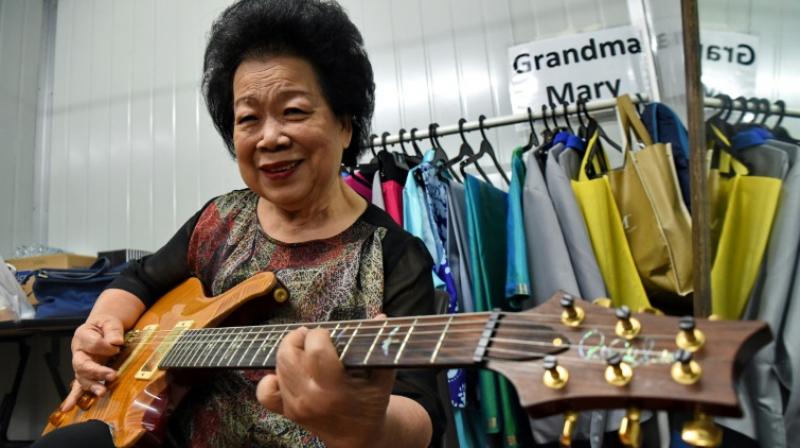 Grandmother of seven Ho only started playing the guitar at 60, fulfilling a lifelong dream to learn the instrument. (Photo: AFP)