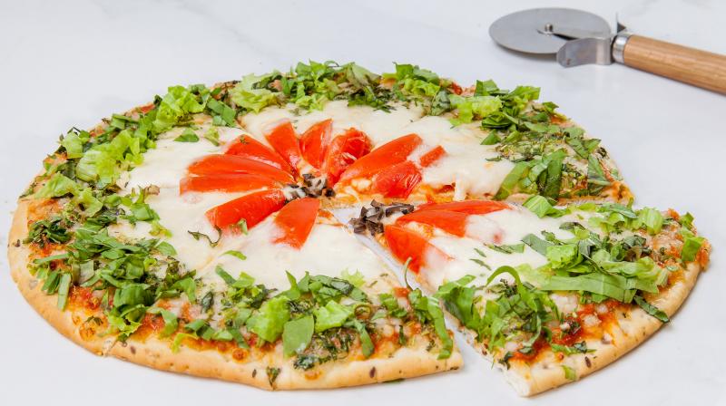 An Indian Caprese Pizza is a vegetarian dish that incorporates totamotes, basil and spinach as a few of its core ingredients