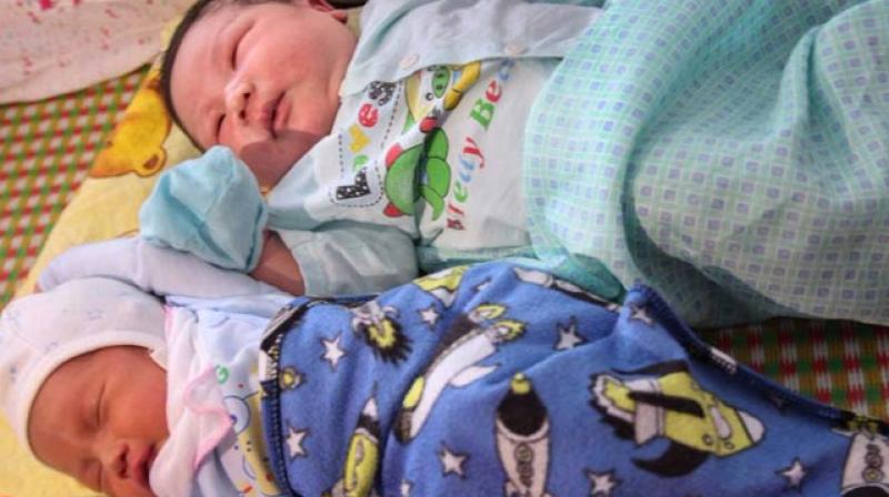 Tran Tien Quoc (top) next to an unidentified baby in the hospital (Photo: AFP)