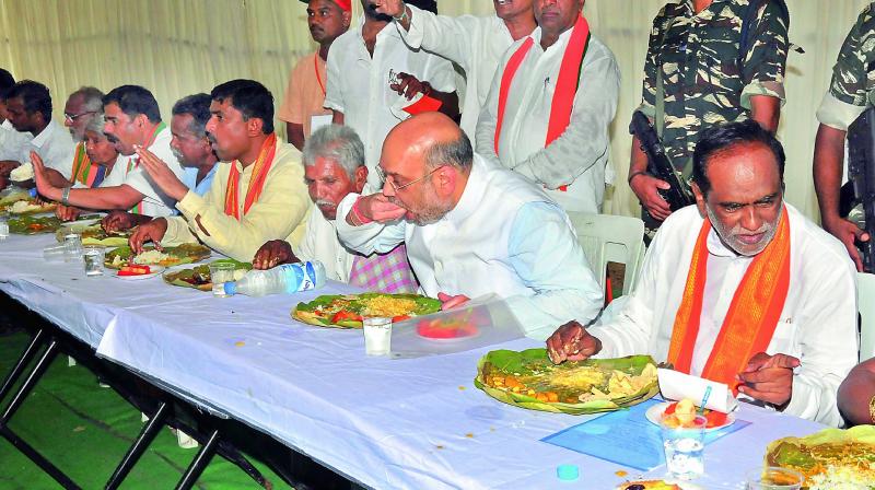 BJP national president Amit Shah having lunch during his door-to-door campaign in a Dalit colony at Theratpally in Nalgonda district on Monday. (Photo: P. Surendra)