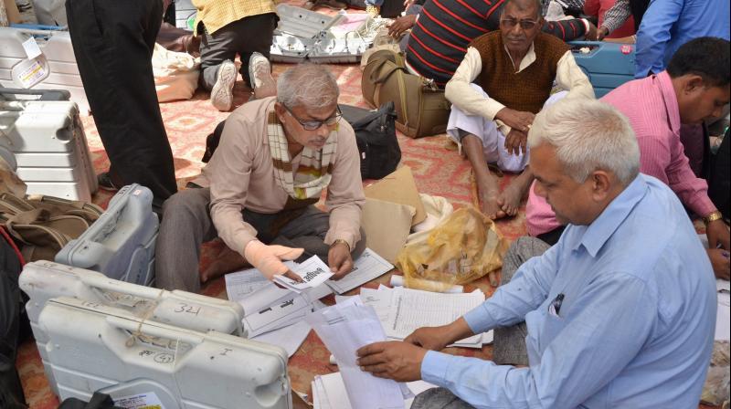 Polling officers collect election material before departing for their respective polling station from a distribution centre for 6th phase of UP Assembly elections in Gorakpur. (Photo: PTI)