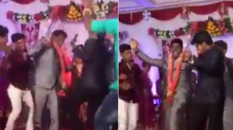 The clip shows the groom enthusiastically dancing with his friends onstage even as other wedding guests and the bride herself looked on. (Credit: Facebook)