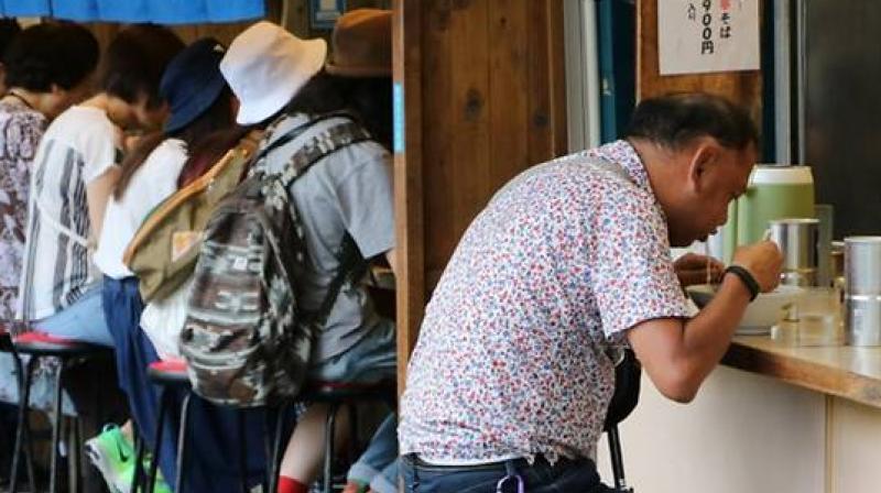 Foreign visitors to Japanese noodle bars are often startled to hear the locals normally so polite, noisily slurping down their noodles. (Photo: AFP)