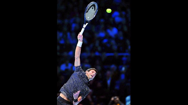 Novak Djokovic of Serbia serves to John Isner of the USA during their mens singles round-robin match at the ATP World Tour Finals tennis tournament at the O2 Arena in London. Djokovic won 6-4, 6-3.	(Photo: AFP)