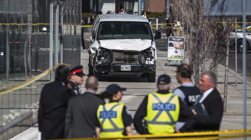 Police seen near a damaged van after a van mounted a sidewalk crashing into pedestrians in Toronto on Monday. (Photo: AP)