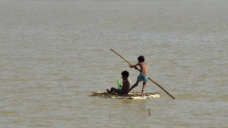 Children use a raft to travel over flood waters in Araria in Bihar on August 19, 2017. (Photo: AFP)