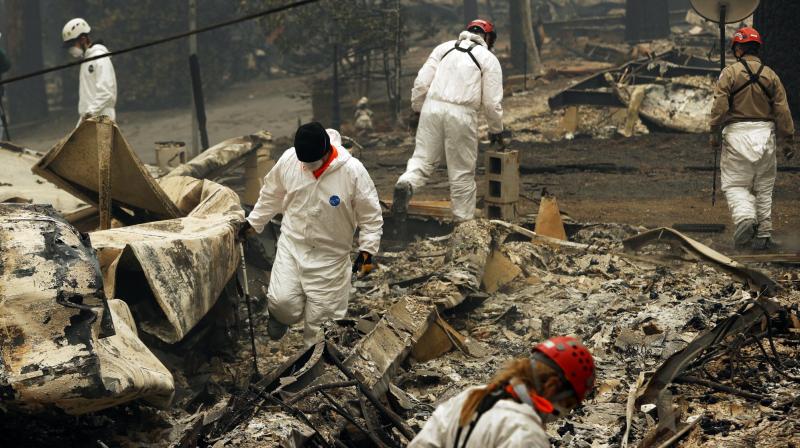 Hundreds of volunteers are sifting through ash and debris, searching for human remains before expected rains complicate their efforts. (Photo: AP)