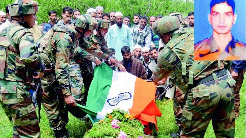 Army personnel pay tributes to the slain army officer Lt. Ummer Fayaz (inset) during his funeral at his native village Sudsona in Kulgam district on Wednesday. (Photo: PTI)