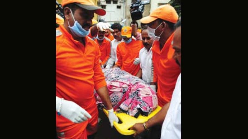 The body of priest Vasudev Bhat is carried by NRDF personnel
