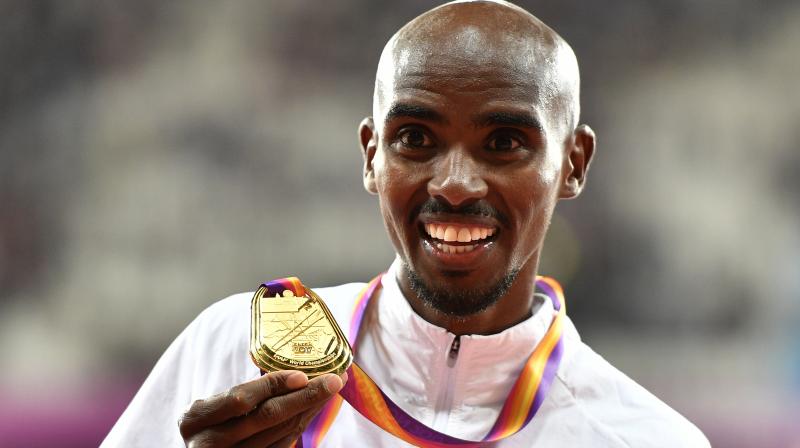 Mo Farah reacts as he holds his gold medal after winning the Mens 10,000 meters final during the World Athletics Championships. (Photo: AP)
