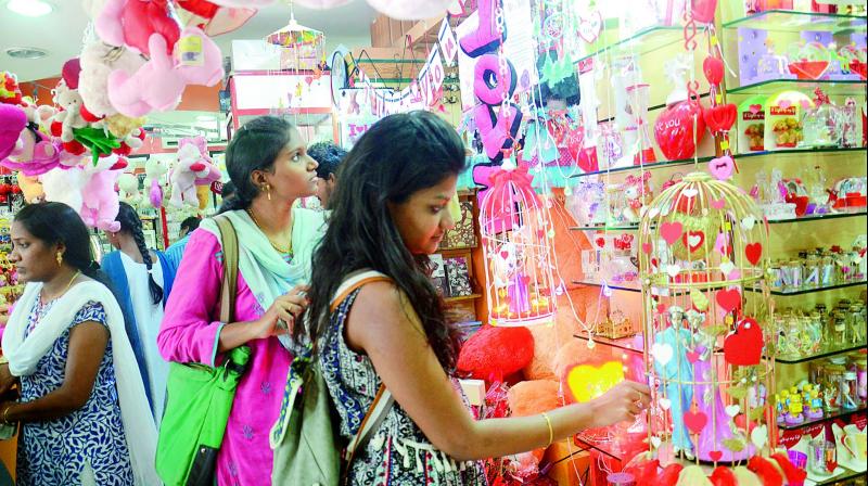 Youngsters check out gift articles at a shop in Visakahapatnam on the eve of Valentines Day, on Monday. (Photo: DC)