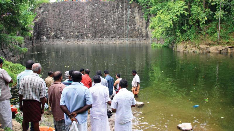 Onlookers gather near the quarry at Ampattukadavu at Paruthumpara where two children drowned in Kottayam on Saturday. (Photo: DC)