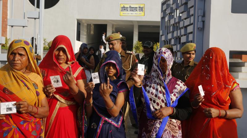 Indian women show their index finger marked with indelible ink after casting their vote at a polling station in Saifai, Etawah, Uttar Pradesh, on Sunday. (Photo: PTI)