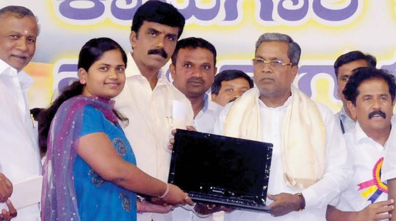 CM Siddaramaiah giving away a laptop to a beneficiary in Mysuru on Sunday (Photo: KPN)