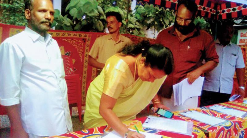 Kalamassery municipal chairperson Jessy Peter signs the mass petition campaign demanding development of HMT junction.