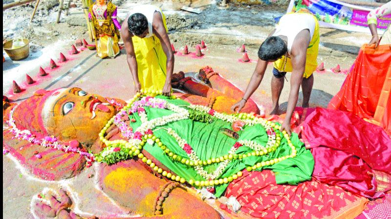 Priests arranging Angala Amman sand sculpture during the Mayana Kollai festival at Kilpauk on Wednesday.  (Right) The festival being celebrated in Vellore. (Photo: DC)