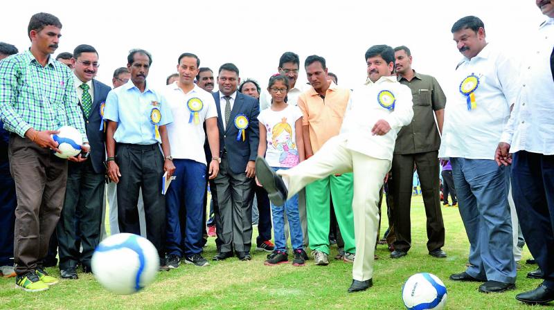 Sports minister Kollu Ravindra kicks the football to mark the inauguration of Oorja Cup U-19 football talent hunt tournament, organised by CRPF at Railway Stadium in Visakhapatnam on Monday. Vizag MP Kambhampati Haribabu is also seen. (Photo: DC)