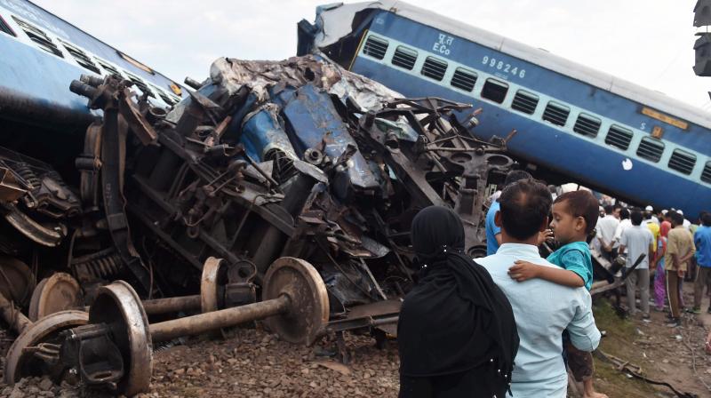 People looking at the wreckage of the rail compartments as workers are carrying out the repair work after Puri-Haridwar Utkal Express derailed in Khatauli near Muzaffarnagar on Saturday. (Photo: PTI)