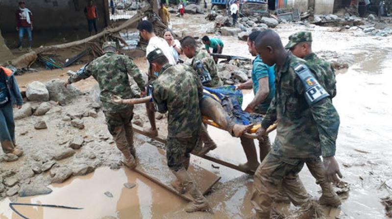 Colombian National Army, soldiers carry a victim on a stretcher, after an avalanche of water from an overflowing river swept through the city as people slept.
