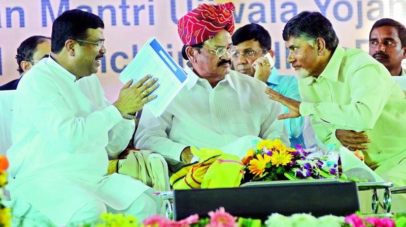 Chief Minister Chandrababu Naidu has a word with minister of state for petroleum Dharmendra Pradhan as Union urban development minister M. Venkaiah Naidu looks on at the foundation stone laying ceremony of IIPE Petroleum University, PM Ujwal Yojana and Dedication of National Skill Development Institute at Sabbavaram in Visakhapatnam district on Thursday. (Photo: DC)
