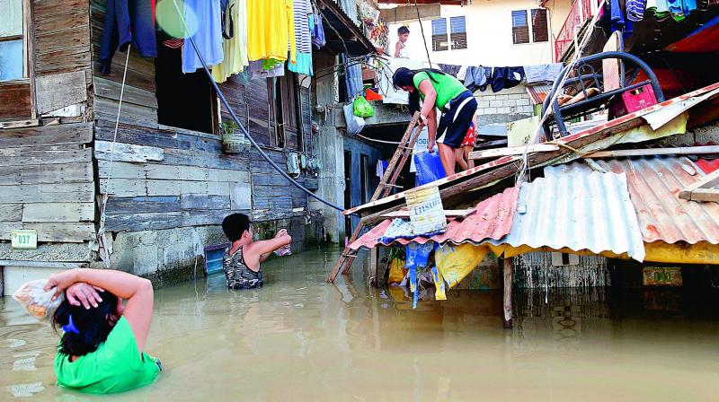 A couple wade through floodwaters to buy drinking water following flooding brought about by Typhoon Mangkhut which barreled into northeastern Philippines, on Monday. (Image: AP)