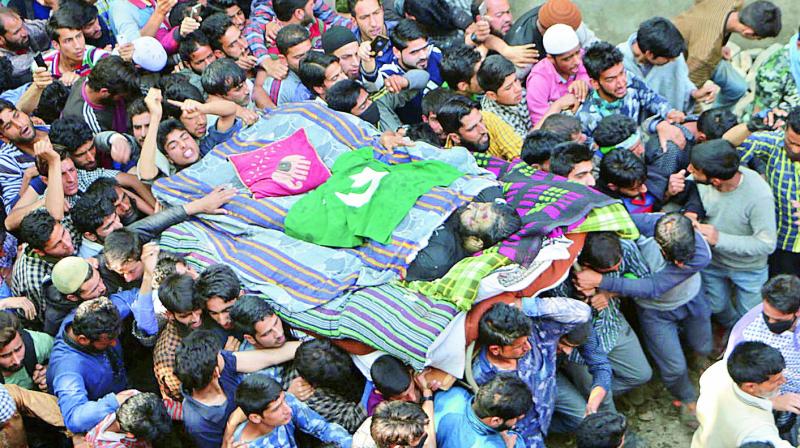 Thousands of people on Sunday attended the funeral of slain Hizb-ul-Mujahedin commander Sabzar Ahmed Bhat in Tral area of Pulwama district. His body was taken out as a procession with the Pakistani flag draped on him. (Photo: H.U. Naqash)