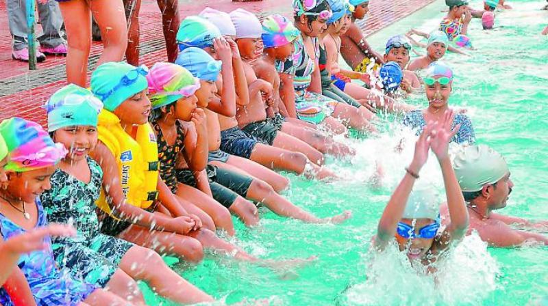 File photo of a group of children participating in a summer swimming coaching camp.