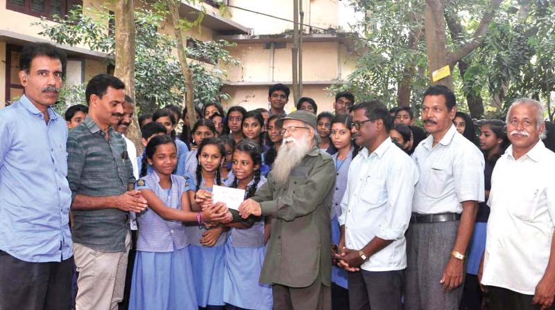 Green activist Prof T Sobeebndran inaugurating the vegetable cultivation in schools by distributing seeds to students at Kozhikode on Friday.