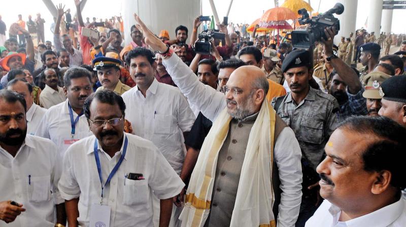 BJP national president Amit Shah waves to supporters as he arrives at the Kannur International Airport in Kannur on Saturday. BJP state president Sreedharan Pillai is also seen.