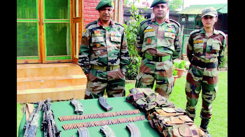 Army personnel display arms and ammunition recovered from the two Hizbul Mujahideen militants who were killed during an encounter, at Bomai in Sopore, north Kashmir, on Thursday. (Photo: PTI)