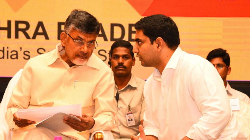 Chief Minister N. Chandrababu Naidu shares a word with IT minister Nara Lokesh at the Mega Job mela valedictory programme in Vijayawada on Saturday. (Photo: DC)