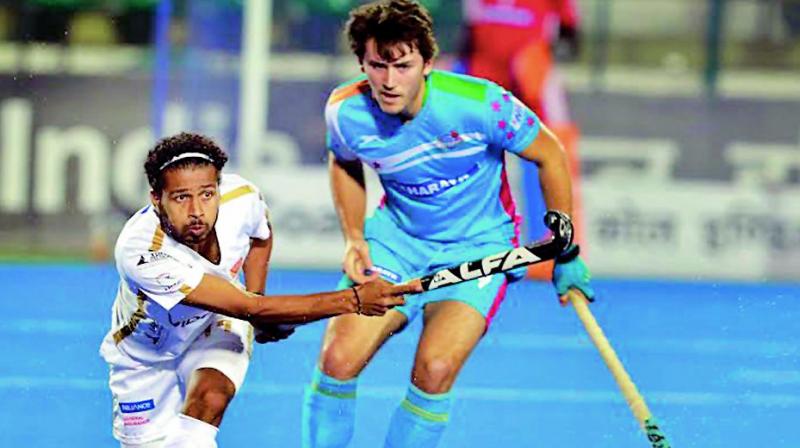 Dabang Mumbais Manpreet Singh (left) vies for the ball with a Uttar Pradesh Wizards defender in their HIL-5 match in Lucknow on Wednesday. The match ended 4-4.