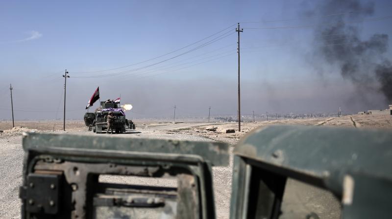 Iraqi police forces fire from a humvee at Islamic State positions from a hillside outside the town of Abu Saif, Monday. (Photo: AP)