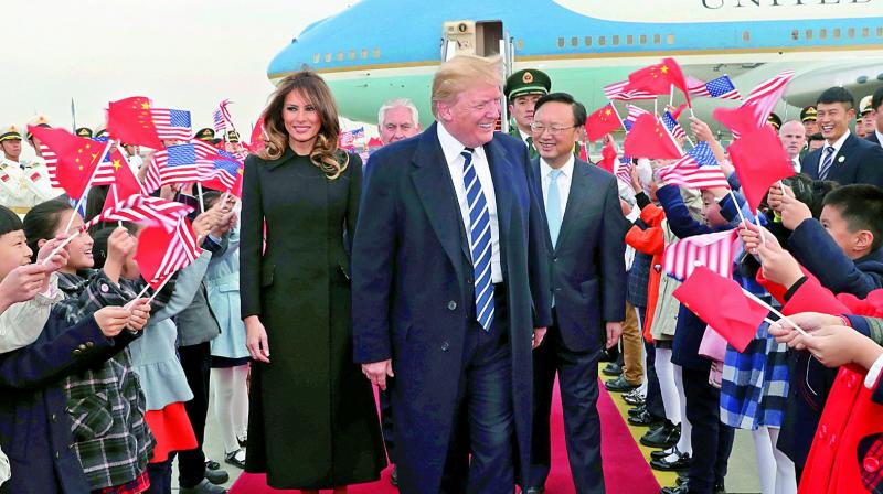 Children wave US and Chinese flags as US President Donald Trump and First Lady Melania Trump arrive at Beijing Airport on Wednesday. (Photo: AFP)