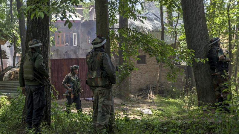 Indian army soldiers take position near the house where two suspected militants were killed in a gunbattle at Saimoh village, in Tral. (Photo: PTI)