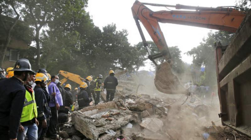 Rescue workers look for survivors at the site of a building collapse in Mumbai. (Photo: PTI)